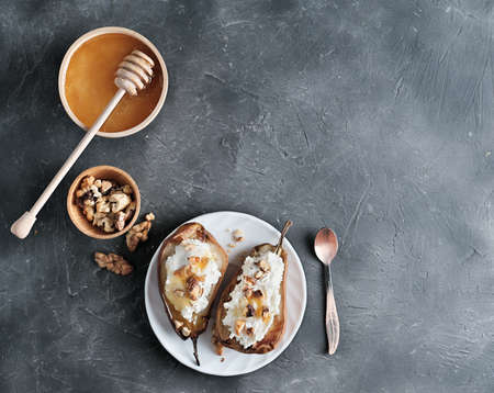 grilled pears baked with mascarpone cheese and nuts. honey topping. sweet dessert for kidsの写真素材