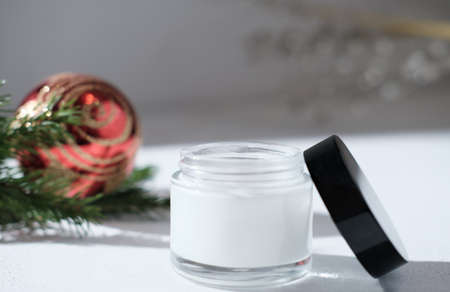 face cream in white jar next to christmas decor, new year sale or holiday present for women. face and skin care, cold protection cosmetic for sensitive skin.の写真素材