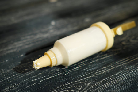 confectionary syringe with cream for cake filing, frosting and decorating desserts. kitchen utencils, culinary tools. selective focusの写真素材