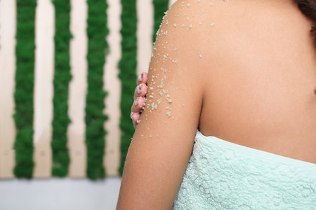 woman applying body exfoliating scrub. natural organic skin polish on her hands. crop view. home spa...