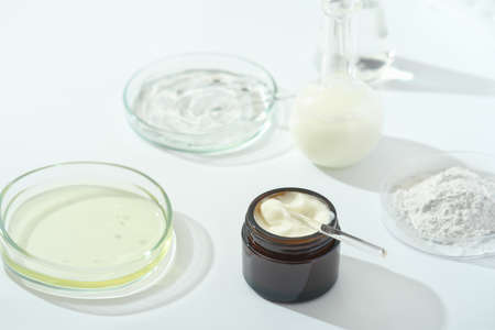 petri dishes with medium and glassware on a laboratory table. fermentation, fermented beauty skin care. container with cream or solution or serum for anti age treatment developed in a lab.の写真素材