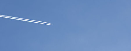jet airplane in a sky with white trace. banner, copy space. travel and air cargo concept. low angle...