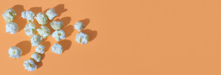 fresh caramel popcorn on an orange background, banner. copy space, flat lay.