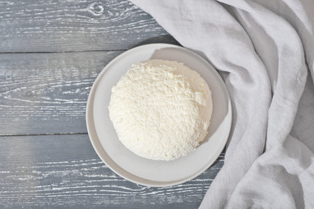 homemade soft cheese on a concrete plate. cottage cheese, high protein dairy product. healthy meal,...