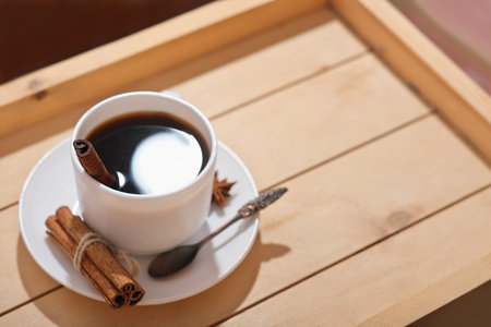 americano espresso coffee in classic white cup. coffee with cinnamon and anice on wooden tray. high angle view. spicy hot winter drinks.の写真素材