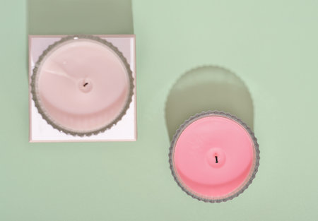 top view of two coconut wax candles on green background. minimal home decor, scented candles for ambient cozy house. selective focusの写真素材
