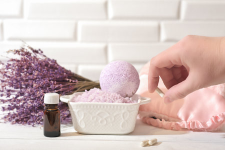 hand holding Melatonin capsules. Relaxing bath salt and bath bomb with lavender oil. Lavender as calming and soothing ingredient for good sleep. insomnia support.の写真素材