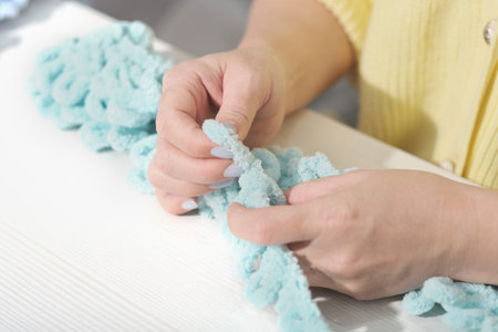 finger knit concept. new way to knit accessories using no needles. hand made knitting. female hands...