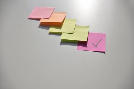 yellow, pink, orange, green stickers on the white boardの写真素材