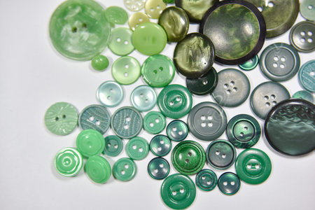 Green buttons of different shape and size on the white background. Selective focus, handcraft...