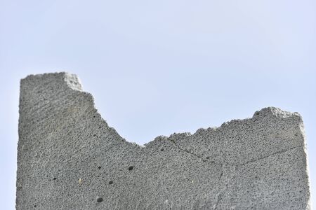 gray brick texture with small holes  and breaks on the blue background. selective focusの写真素材