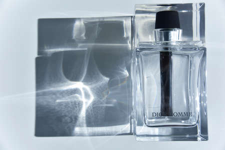 the bottle of Christian Dior Homme perfume with the sunlight going through and making light effects and light refraction. Editorial fashion concept.のeditorial素材