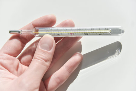 Thermometer in the female hand with the scale visible.