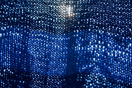 the look at the sun through the blue knitted cloth. Selective focusの写真素材