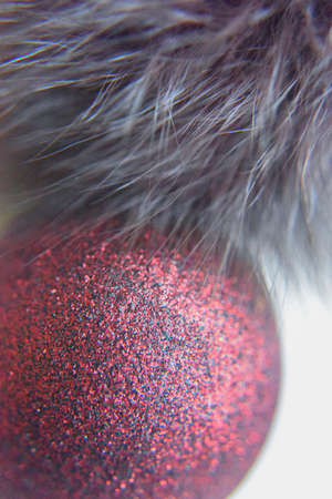 selective focus at the red ball with glitters on the surface. copy space on the white background with the gray furの写真素材