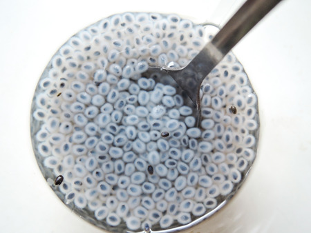 Top view of swollen Chia seeds in a glass with water and a spoon.の写真素材