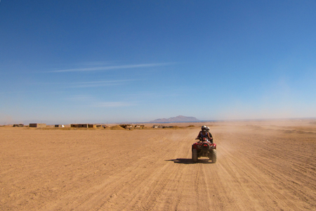 a couple in love travels through the desert on a Quad bikeの写真素材