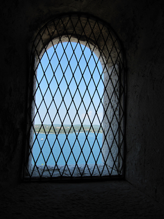 cell wall with a window with bars with sea view, interior perspectiveの写真素材