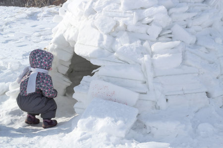 The child looks into the house of Eskimos-igloo