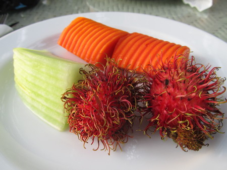 Exotic fruit on a plate. Rambutan and papayaの写真素材