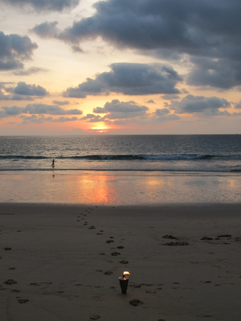 Burning torch on romantic beach at sunset in Thailand.の写真素材