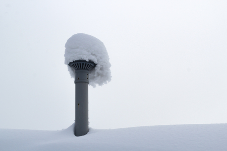Huge layer of snow on the roof and ventilation pipeの写真素材