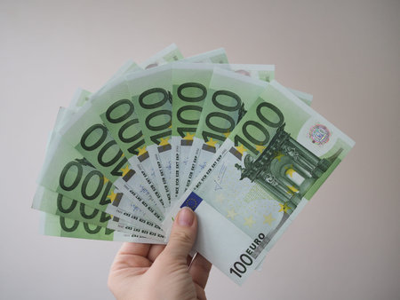 a woman holds in her hand a lot of banknotes in denominations of 100 euros fan.