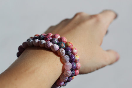 bracelets made of natural stones on a woman's hand close up.