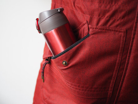 close up of water mug in side pocket of jacket.