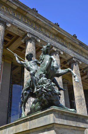 The statue Fighter with a Lion architect Albert Wolff against the background of the columns of the Altes Museum. Museum Island of Berlinのeditorial素材