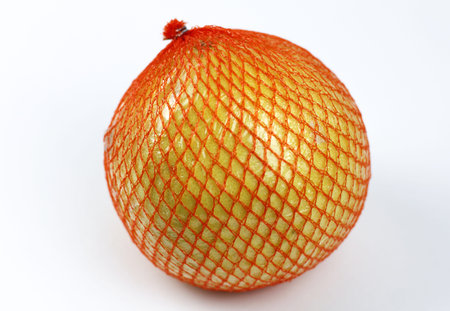 A ripe pomelo is packaged in a grid on a white.