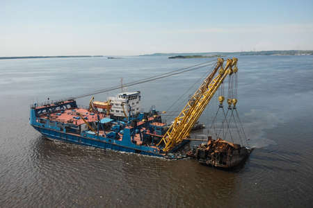 Russia, Saratov - june, 2020. industrial ship crane removed the old sunken ship from the river.のeditorial素材
