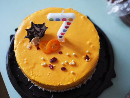 Birthday cake with 7 number pink candles and burning sparkler on blue backgraund. Close-up