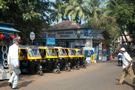 India, Goa-February, 2009: Yellow black rickshaws tuk tuk lined up in the street of Udaipur,...