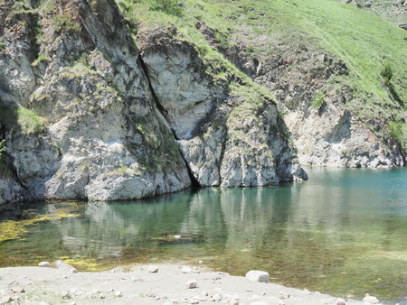rocky mountains. near the pond with clear mountain clear water and mountains with Alpine meadowsの写真素材