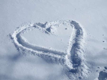 Symbol of heart on the background of fresh snow texture in blue tone. Merry Christmas or Valentines Day Concept. Copy space for your text. High resolution productの写真素材