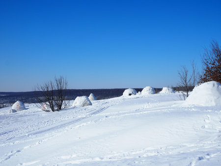 igloo and snow shelter in high snowdrift with mountains peaks on background