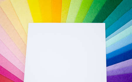 The square pieces of felt spread out by a color spectrum on similarity of a rainbow: from shades of red, pink, yellow, green, blue and bright violette at the end. White paper for copy space.の写真素材