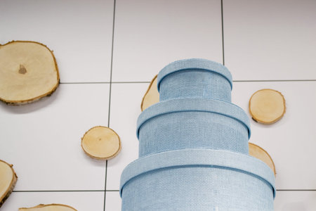 Beautiful storage boxes of pale blue color, on the shelves on white background and wooden circles....