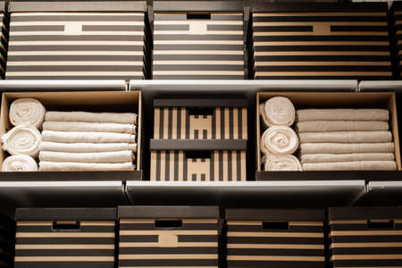 Cardboard striped boxes and white towels on hanging shelves. The concept of home storage.の写真素材