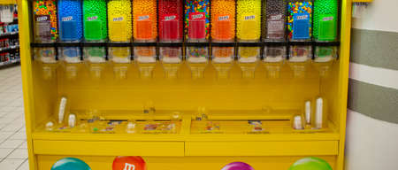 Moscow, Russia, November 2019: MM Candies at Candy Dispenser Machines in the supermarket. Colorful button-shaped chocolates in bulk.のeditorial素材