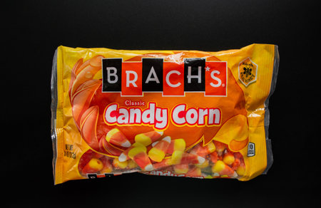 Candy corn packaging. Traditional sweets on Halloween. Treat or trick. Black background.