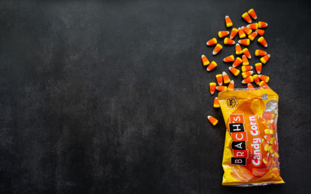 Candy corn candies spilled out of pack. Traditional sweets on Halloween. Treat or trick. Copy space.
