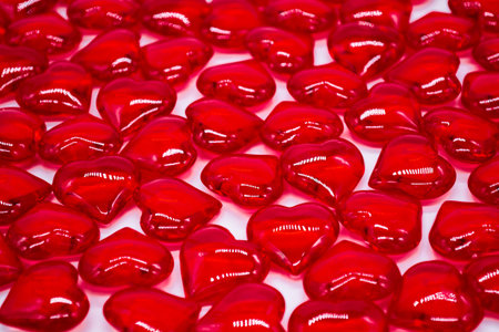 A large number of bright red hearts shiny, glass on a white background. Concept of love, marriage,...