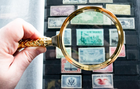Moscow, Russia, March 2022: Hobby: collecting stamp. Looking at blurred old stamps through a golden...