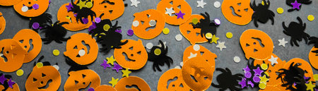 Banner with Halloween background: shiny confetti in the shape of orange pumpkins, black spiders and purple, golden stars.の写真素材