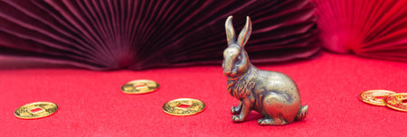 Banner with a bronze figure of a bunny hare with golden coins - the symbol of the Chinese new year...
