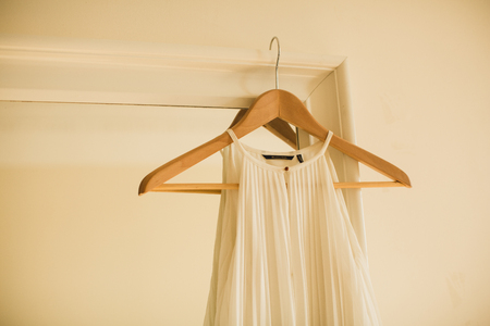 white wedding dress on a hanger hanging on mirrorの写真素材