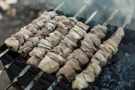 meat on grill with flames in villageの写真素材