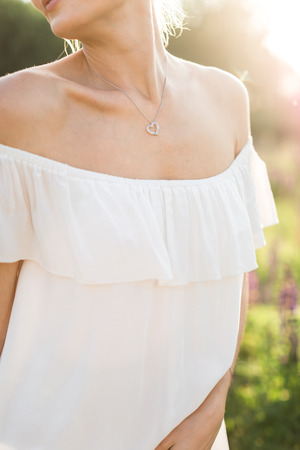 beautiful young woman in white dress in flower fieldの写真素材